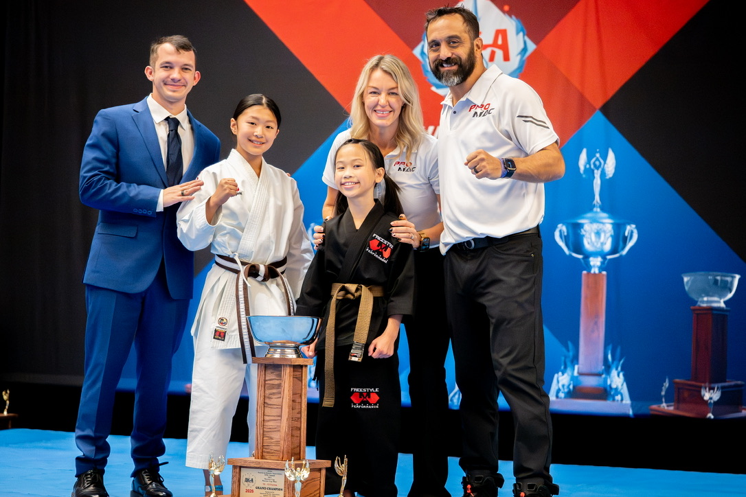 PROMAC leadership with two young Grand Champions on the 2026 AKA Warrior Cup stage