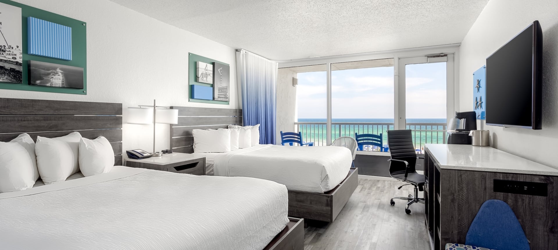 A Gulf-front guest room with two beds and a balcony at The Island Resort